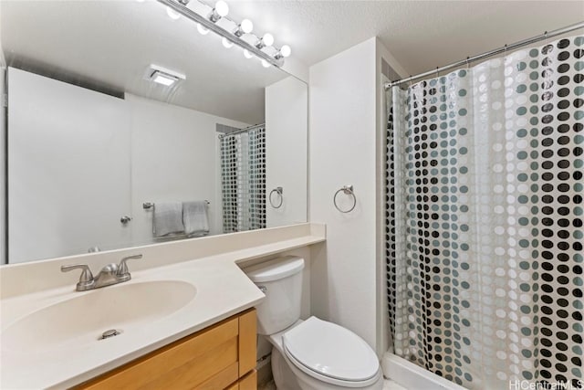 bathroom featuring vanity, curtained shower, toilet, and a textured ceiling