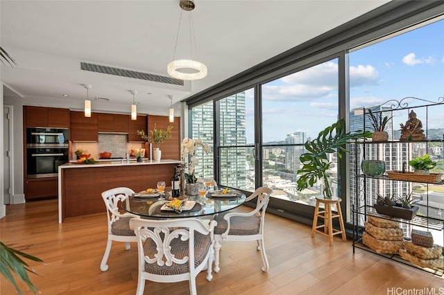 dining room with light hardwood / wood-style floors and a wall of windows