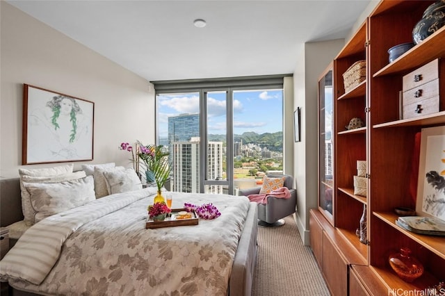 bedroom featuring expansive windows and carpet floors