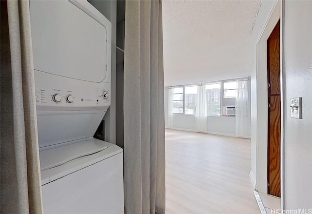 washroom featuring light wood-type flooring and stacked washer and dryer