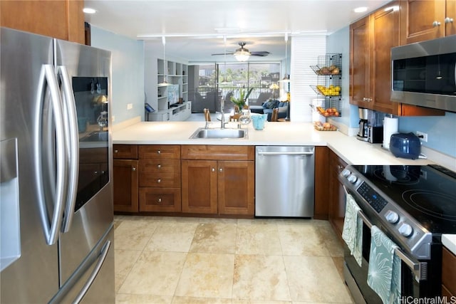 kitchen featuring kitchen peninsula, stainless steel appliances, ceiling fan, and sink