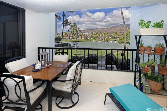 balcony featuring a water and mountain view