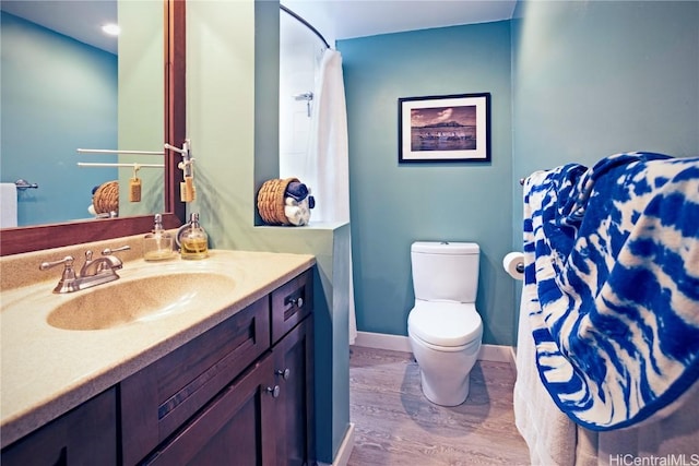 bathroom featuring vanity, toilet, and wood-type flooring