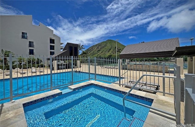 view of pool with a mountain view, a patio, and a hot tub