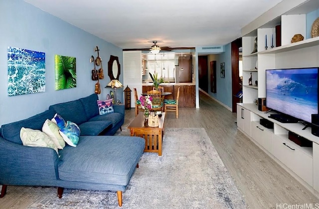 living room featuring ceiling fan and light wood-type flooring