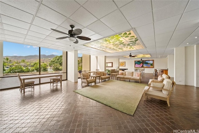 interior space with a mountain view, ceiling fan, and a drop ceiling