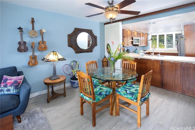 dining room featuring ceiling fan, light hardwood / wood-style flooring, and sink