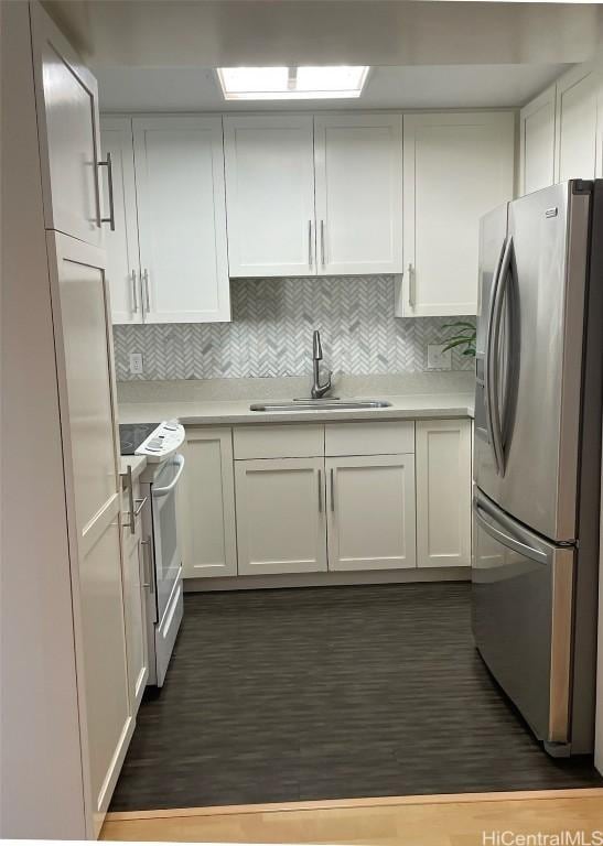 kitchen featuring stainless steel fridge, decorative backsplash, white electric range oven, white cabinets, and sink