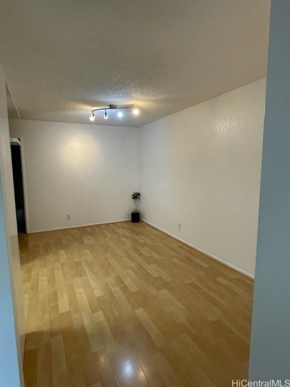 basement with a textured ceiling and hardwood / wood-style floors