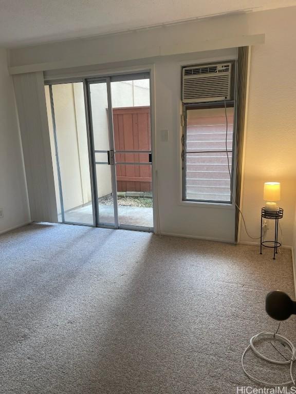 empty room with carpet and a wall mounted air conditioner