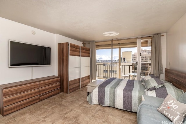 bedroom featuring access to exterior and a wall of windows