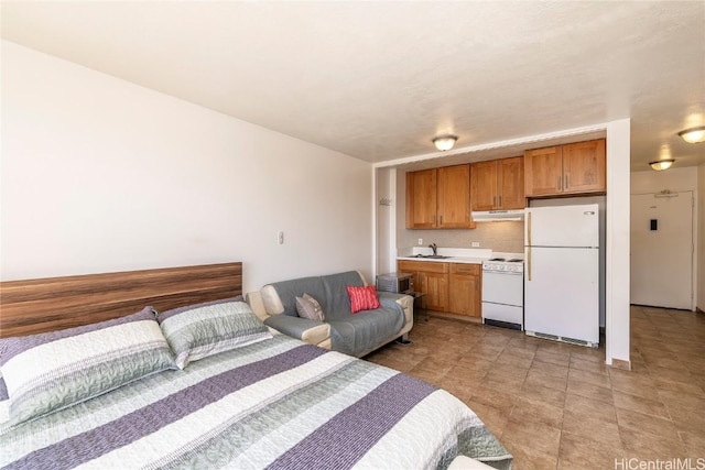 bedroom featuring sink and white fridge