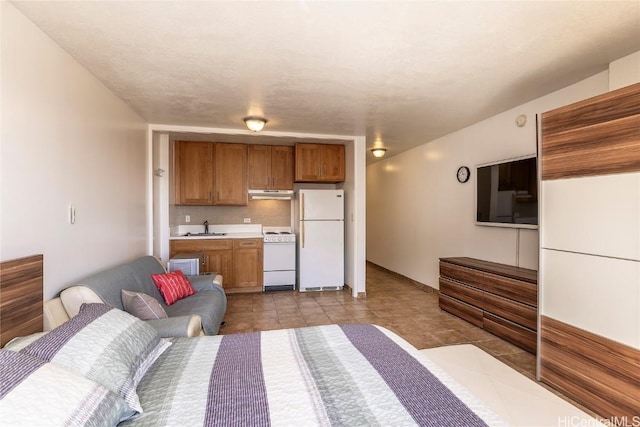 unfurnished bedroom featuring white refrigerator and sink