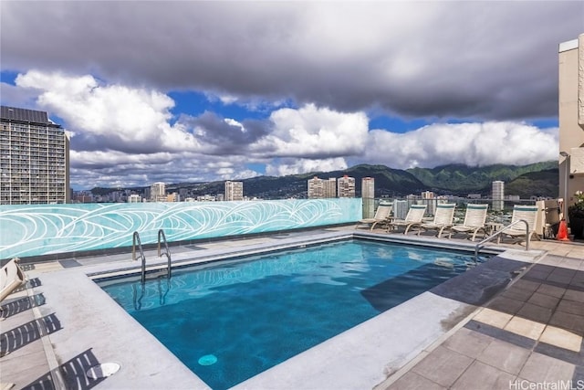 view of swimming pool featuring a mountain view and a patio area