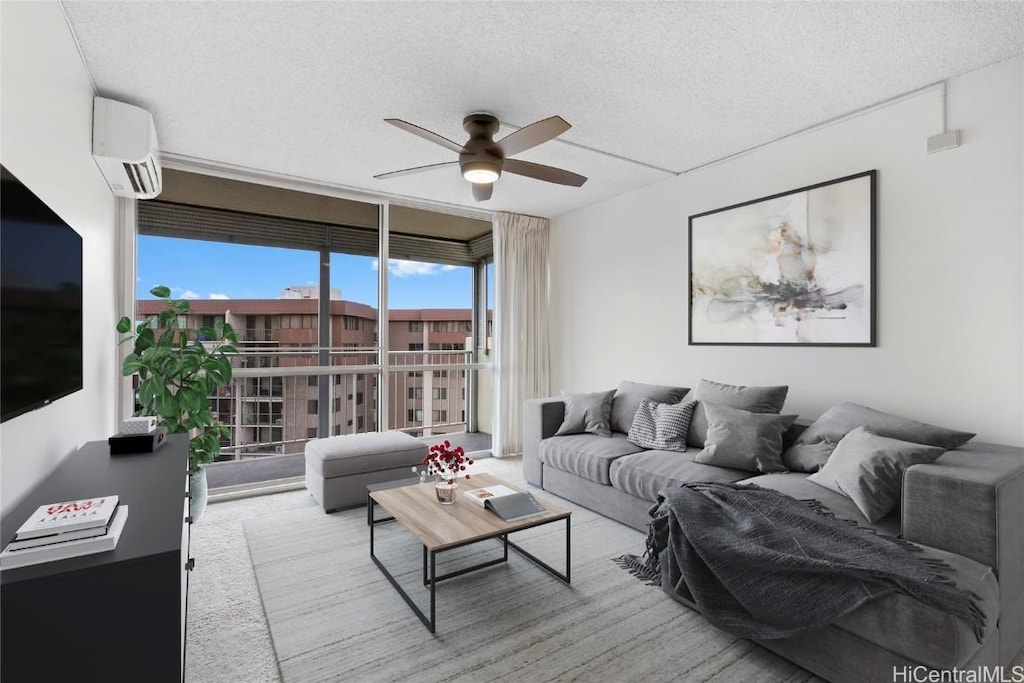 living room featuring an AC wall unit, ceiling fan, and a textured ceiling