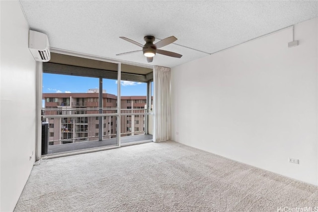 spare room with ceiling fan, carpet floors, a textured ceiling, and a wall unit AC