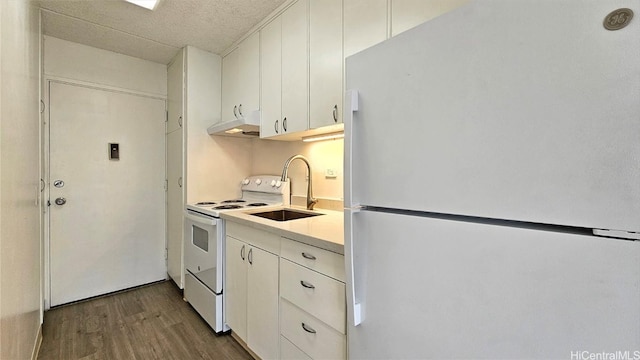 kitchen featuring a textured ceiling, white appliances, dark wood-type flooring, sink, and white cabinets