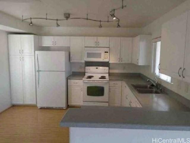 kitchen featuring kitchen peninsula, white cabinetry, sink, and white appliances