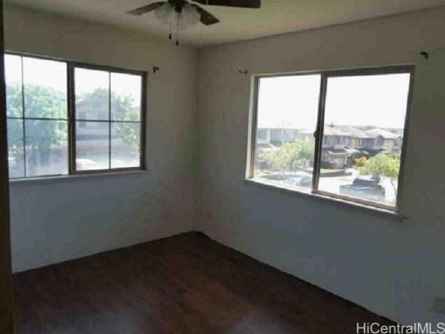 spare room with ceiling fan and dark hardwood / wood-style flooring