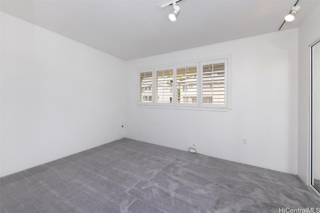 spare room with carpet flooring and rail lighting