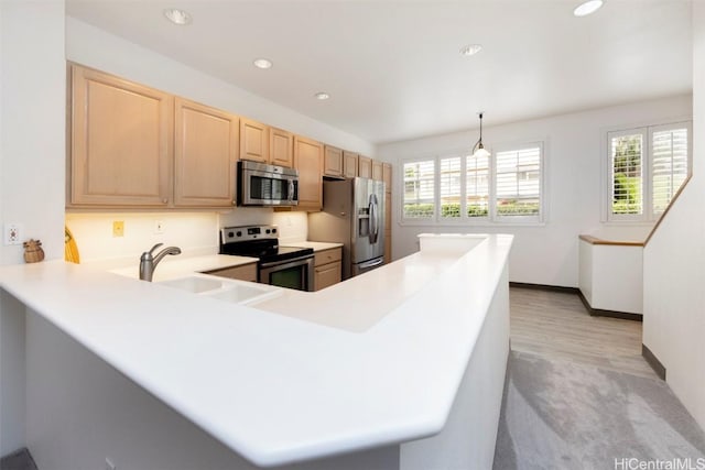 kitchen with decorative light fixtures, kitchen peninsula, light brown cabinetry, and appliances with stainless steel finishes