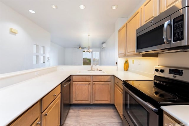 kitchen with ceiling fan, sink, stainless steel appliances, light hardwood / wood-style flooring, and kitchen peninsula