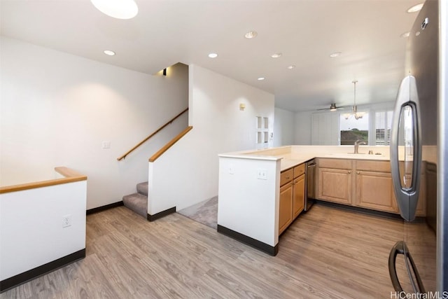 kitchen with sink, light hardwood / wood-style flooring, ceiling fan, appliances with stainless steel finishes, and kitchen peninsula