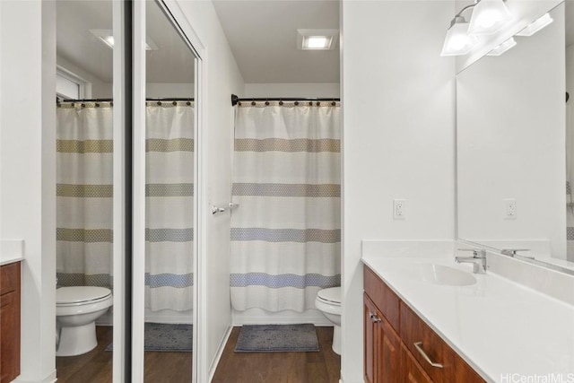 bathroom with a shower with curtain, vanity, toilet, and wood-type flooring