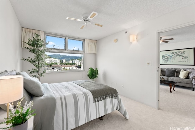 bedroom with carpet flooring, ceiling fan, and a textured ceiling