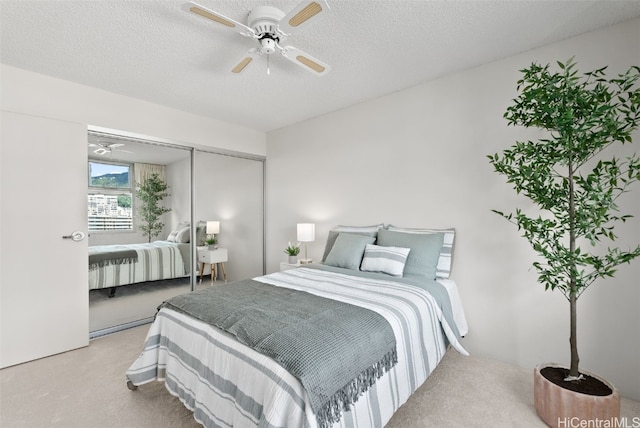 carpeted bedroom with a textured ceiling, a closet, and ceiling fan