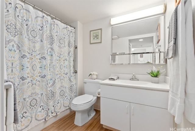 bathroom featuring a shower with shower curtain, wood-type flooring, vanity, and toilet