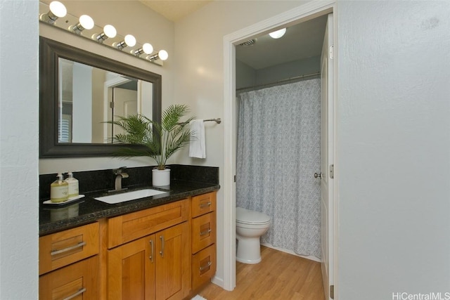 bathroom featuring hardwood / wood-style flooring, vanity, toilet, and a shower with shower curtain