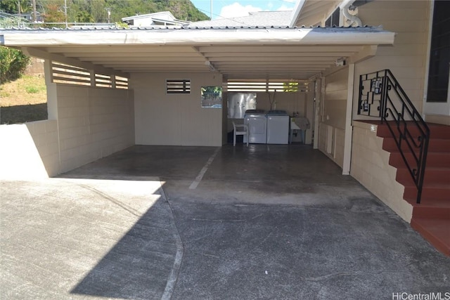 garage with independent washer and dryer, sink, and a carport