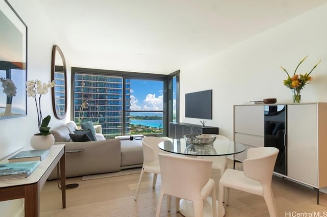 dining space featuring floor to ceiling windows and light hardwood / wood-style floors