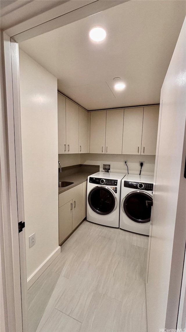 laundry room featuring separate washer and dryer, a sink, and cabinet space