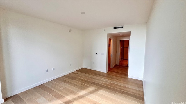 empty room with baseboards, visible vents, and light wood-style floors