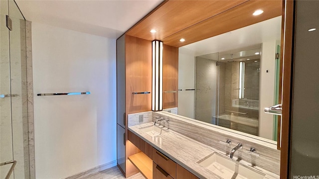 full bath featuring a sink, a stall shower, and double vanity