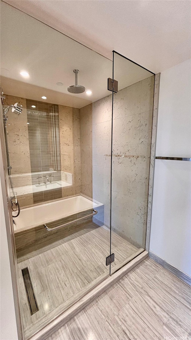 full bath featuring recessed lighting, a bath, and a stall shower