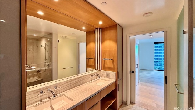 bathroom featuring hardwood / wood-style floors, vanity, and a shower with door