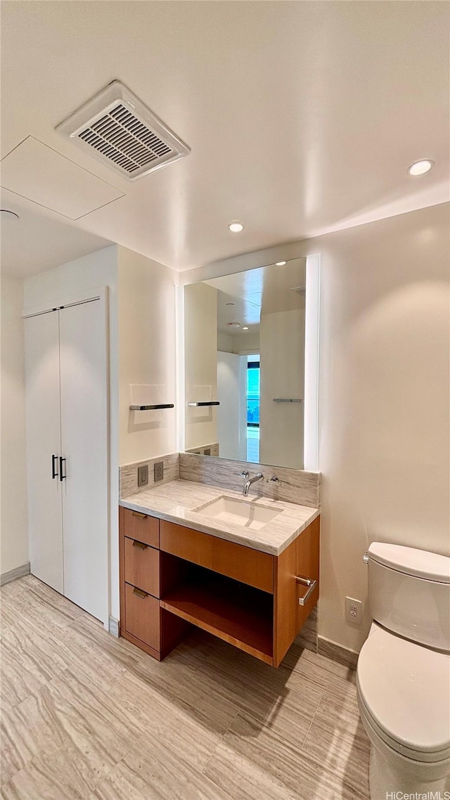 bathroom with recessed lighting, vanity, toilet, and visible vents