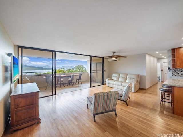 living room featuring ceiling fan and light hardwood / wood-style floors