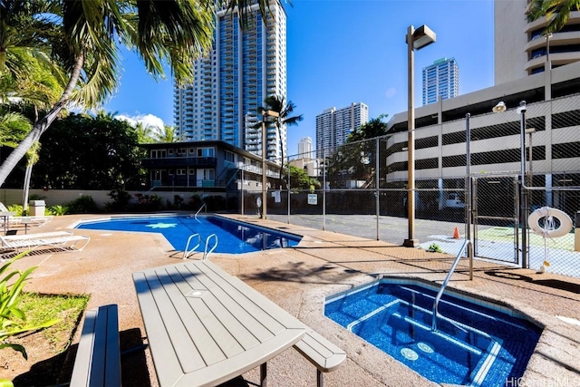 view of swimming pool featuring a community hot tub and a patio