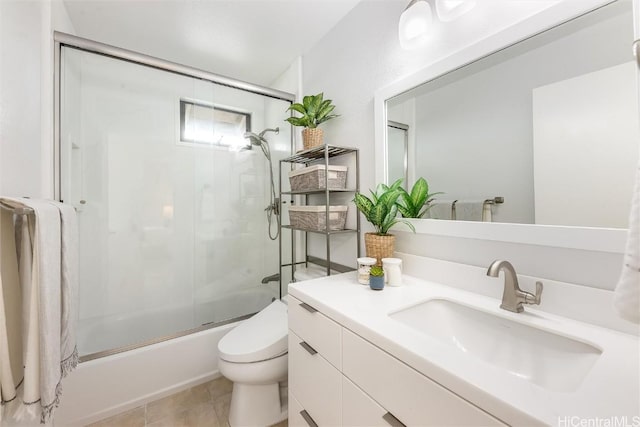 full bathroom with vanity, bath / shower combo with glass door, tile patterned floors, and toilet