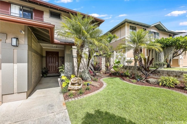 entrance to property with a lawn