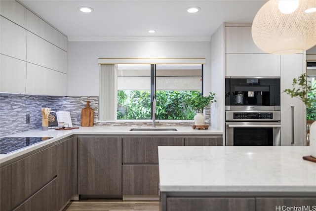 kitchen with white cabinetry, backsplash, dark brown cabinets, and sink