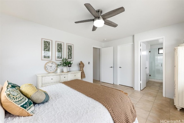 bedroom featuring connected bathroom, light tile patterned floors, and ceiling fan