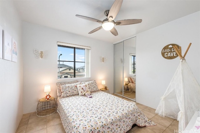 bedroom featuring ceiling fan, a closet, and light tile patterned floors