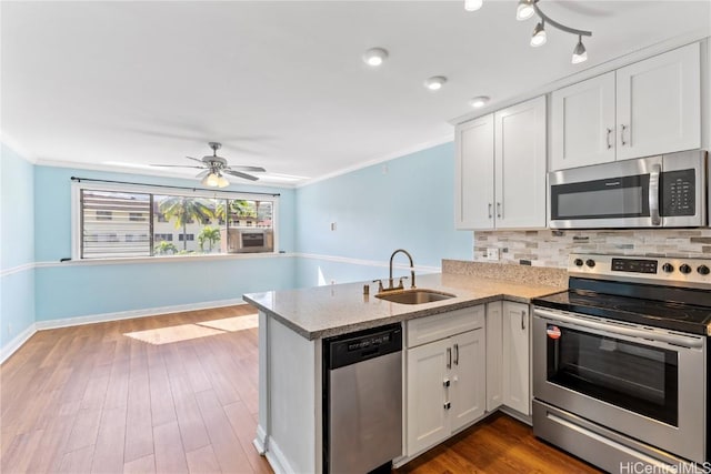 kitchen with white cabinets, sink, kitchen peninsula, and stainless steel appliances