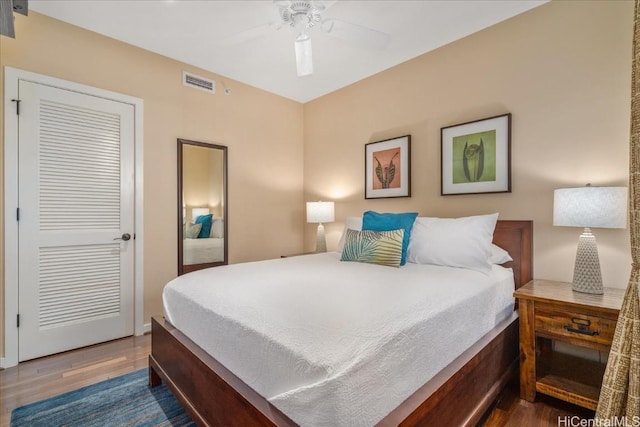 bedroom featuring ceiling fan, dark hardwood / wood-style floors, and a closet