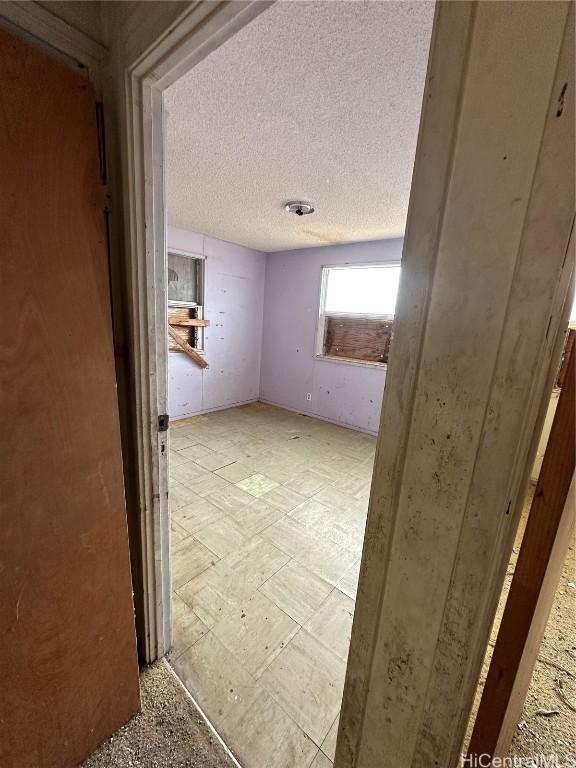 hall featuring a textured ceiling